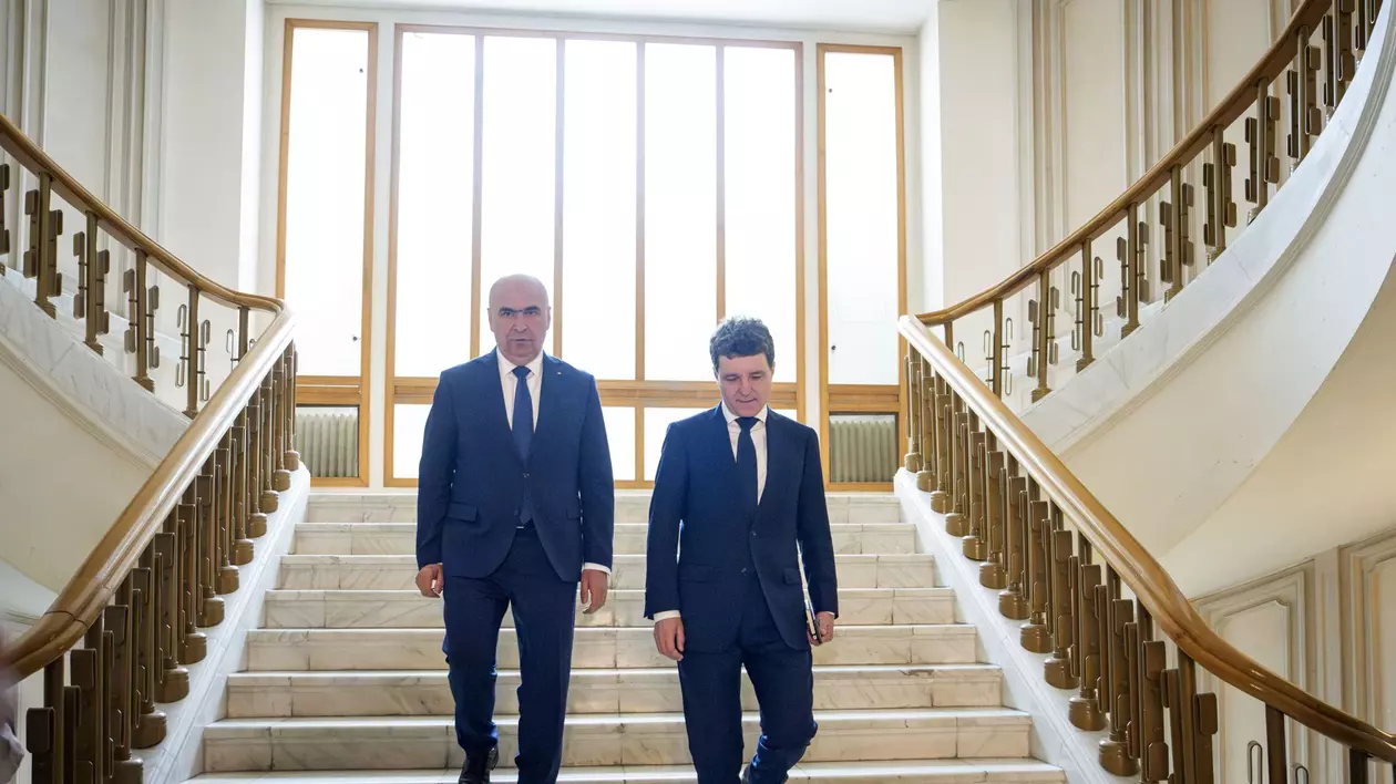 Ilie Bolojan (stânga) și Nicușor Dan (dreapta) surprinși în timp ce coboară scările la sediul Curții Constituționale a României, pe 22 mai 2025