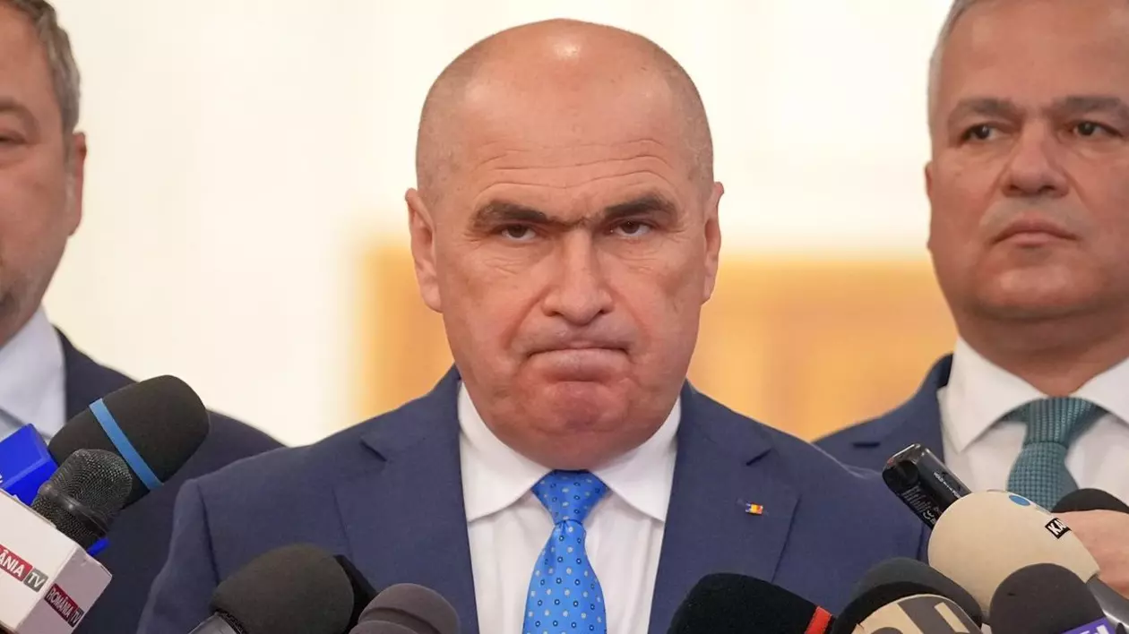 Ilie Bolojan privește fix în camera foto, cu buzele strânse, având o atitudine necruțătoare