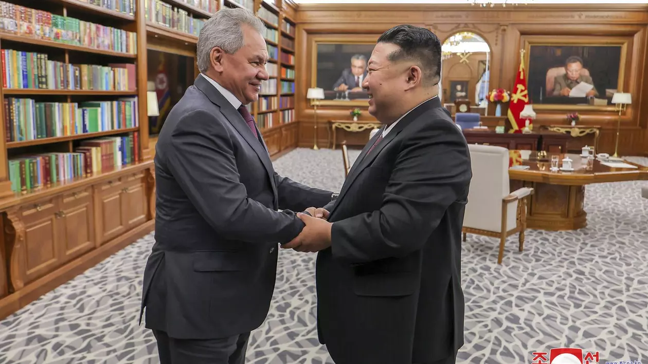 Kim Jong Un (dreapta) surprins în timp ce dă mâna cu Serghei Șoigu (stânga), în timpul vizitei la Phenian.