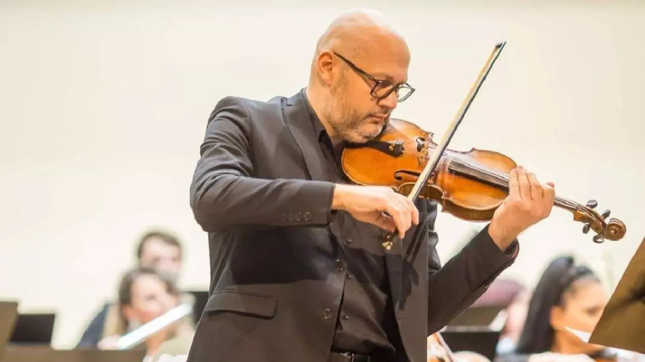 Mădălin Sandu cântă la vioară, în timpul unui concert.