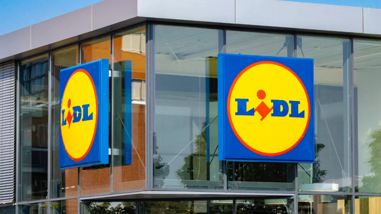 Imaginea prezintă o fațadă modernă de sticlă a unui magazin Lidl.