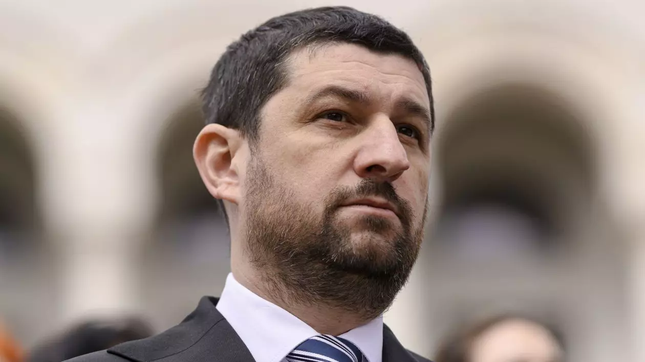 Marius Lulea, vicepreședintele AUR, în prim plan, îmbrăcat cu costum, cămașă albă și cravată albastră
