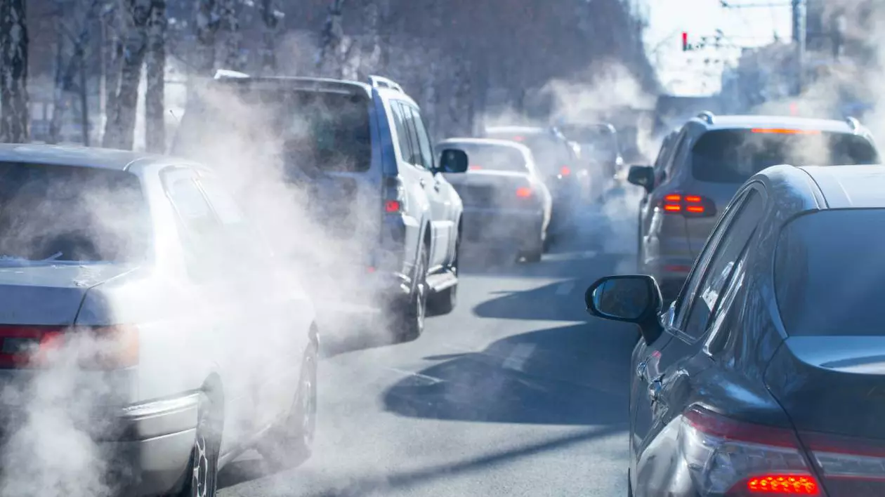 Mașini vechi, blocate în aglomerația din trafic în timp ce se vede și fumul gazelor de eșapament.