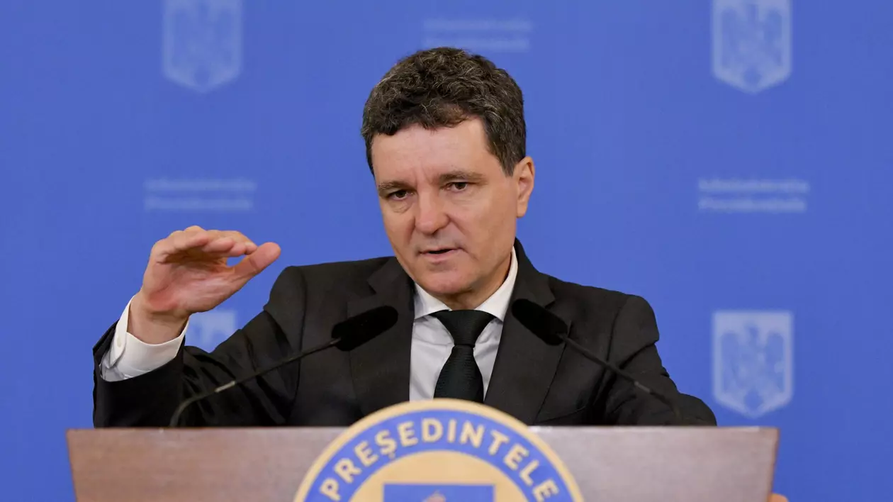 Președintele României Nicușor Dan susâine o conferință de presă și este cu mâna dreaptă ridicată