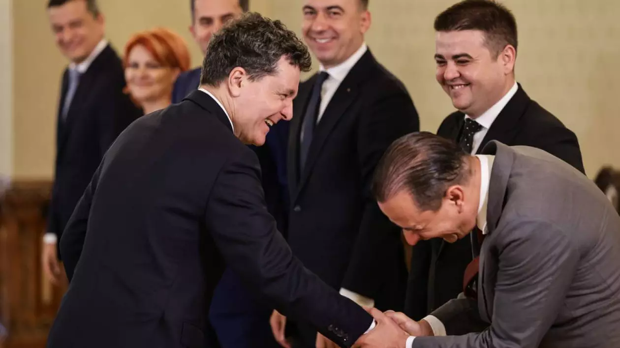 Daniel Băluță stă aplecat în fața lui Nicușor Dan și râde în timp ce îi strânge mâna în ambele mâini