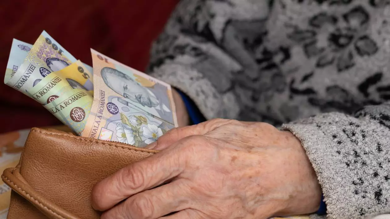 O femeie în vârstă care stă jos și își numără banii din portofel.