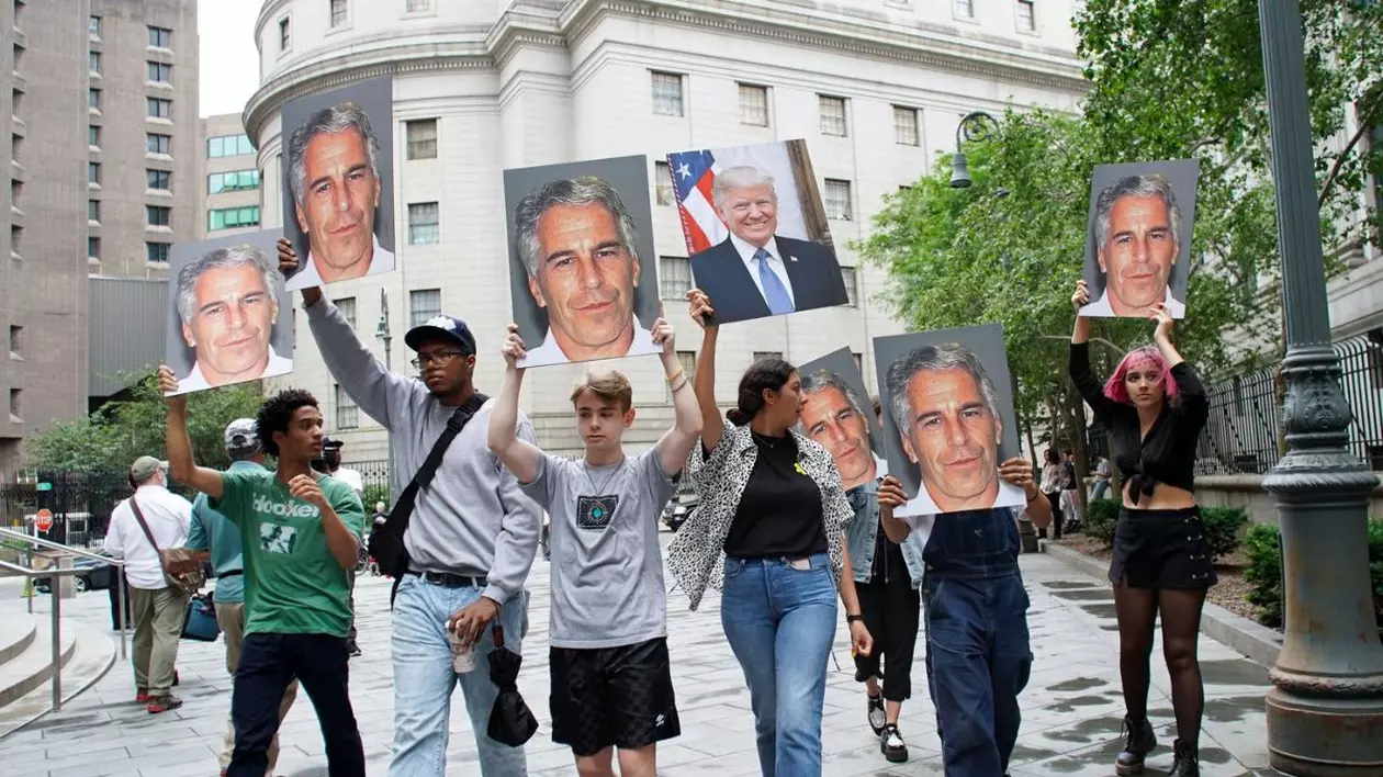 Oamenii țin în mâini fotografii ale lui Jeffrey Epstein și ale președintelui Donald Trump, în timp ce miliardarul Jeffrey Epstein așteapta audierea pentru eliberarea pe cauțiune, iulie 2019