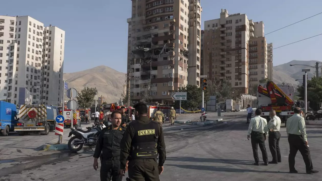 Polițiștii din Teheran și forțele militare în fața unui bloc care a fost bombardat