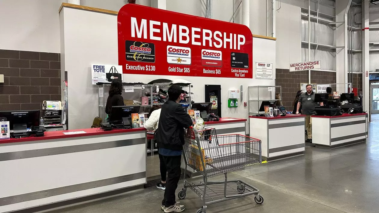 Un ghișeu pentru abonamente Costco, unde clienții sunt asistați de angajați, cu un panou mare care afișează opțiunile de abonament.