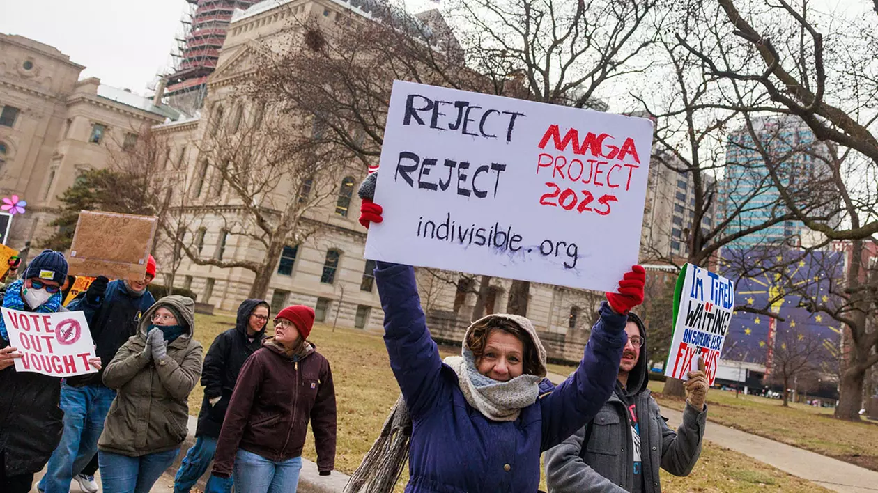 Un demonstrant ține o pancartă pe care scrie „Respingeți «proiectul MAGA 2025»”, în timpul unui protest anti-Trump la Reședința de Stat din Indiana, Indianapolis