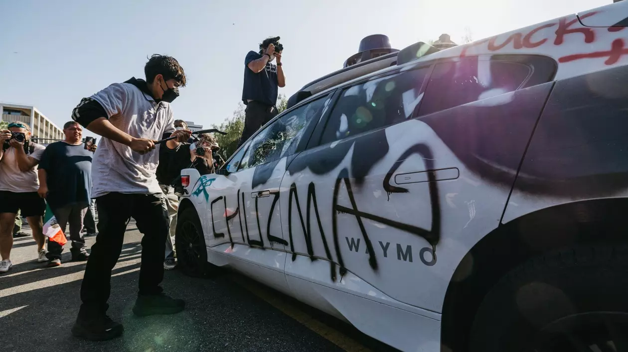 Protestatar surprins în timp ce atacă o mașină în timpul demonstrațiilor din Los Angeles, pe 8 iunie 2025