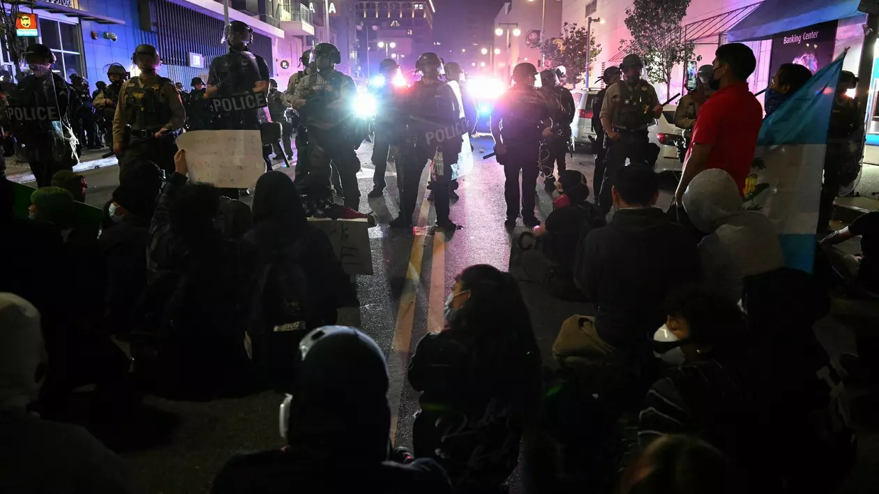 Protestatarii stau în stradă în fața unor polițiști, în timpul unui protest legat de imigrație în cartierul Little Tokyo din centrul orașului Los Angeles, pe 9 iunie 2025.