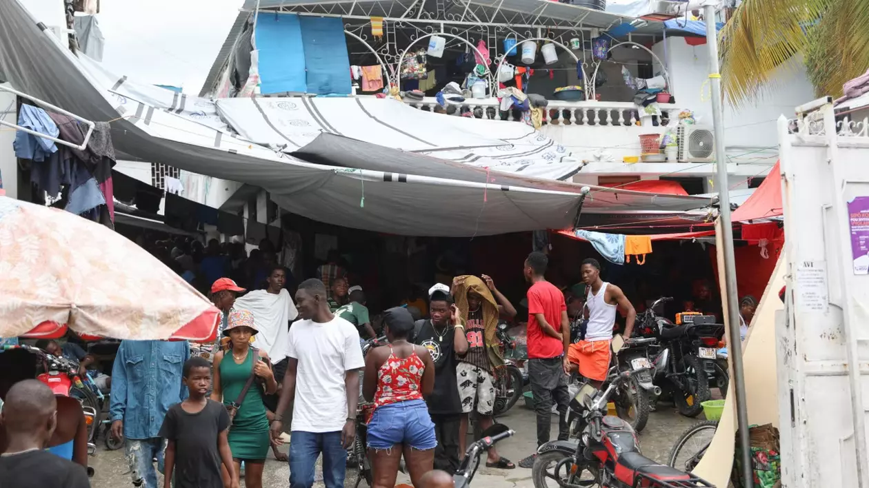 Peisaj dintr-o tabără de refugiați din Haiti, oameni stau în adăposturi improvizate.