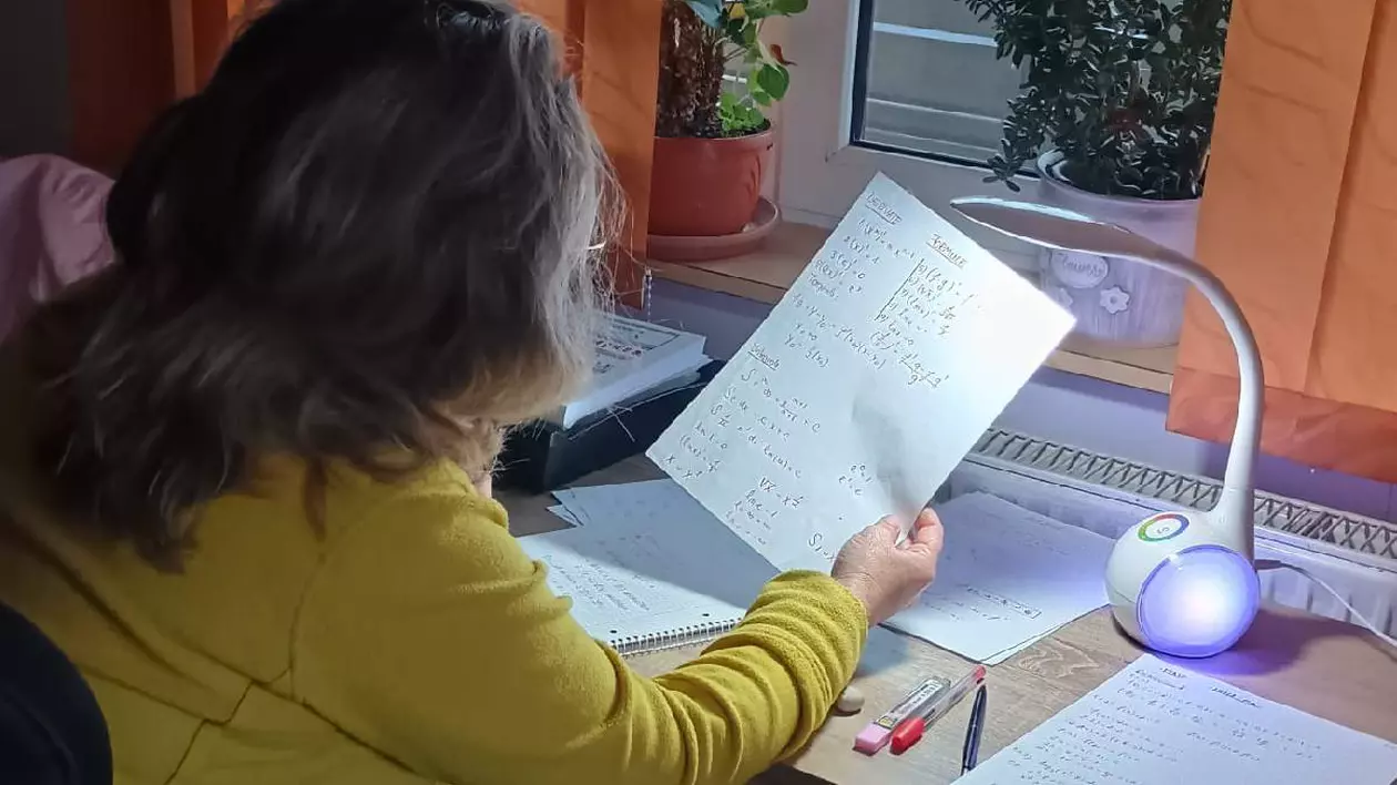 Femeia care stă la biroi și învață și citește un text de pe o foaie