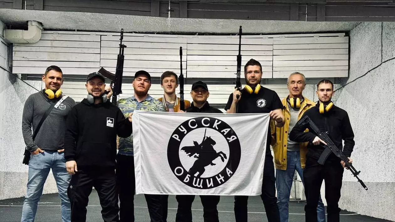 Russkaya Obshchina („Comunitatea Rusă”), un grup de rusi cu arme in maini tinand un banner cu insemnele organizatiei