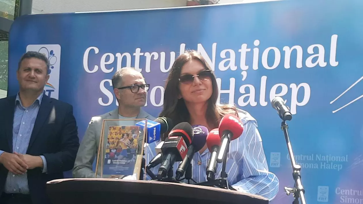 Simona Halep vorbind la microfon în timpul unei conferințe de presă, doi bărbați sunt în background în partea stângă.