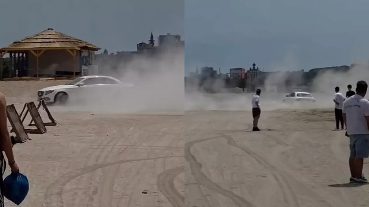 Momentul în care șoferul de Mercedes alb face drifturi pe plaja din Constanța și ridică nori de nisip în jurul lui.
