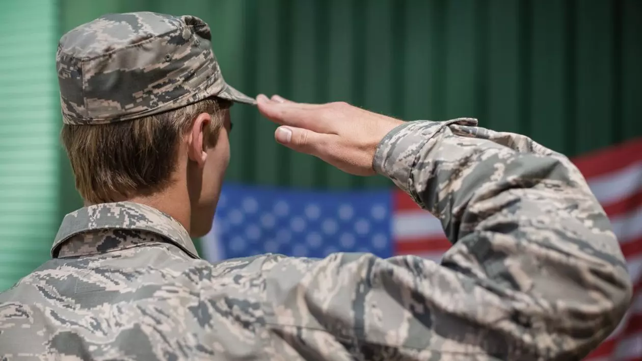 soldat militar salutând steagul american