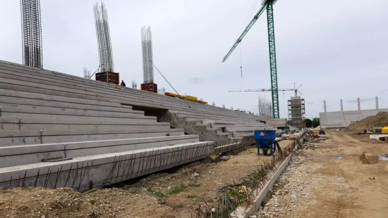stadionul timisoarei este in constructie. in imagine se vad niste tribune de beton, mormane de nisip si o macara