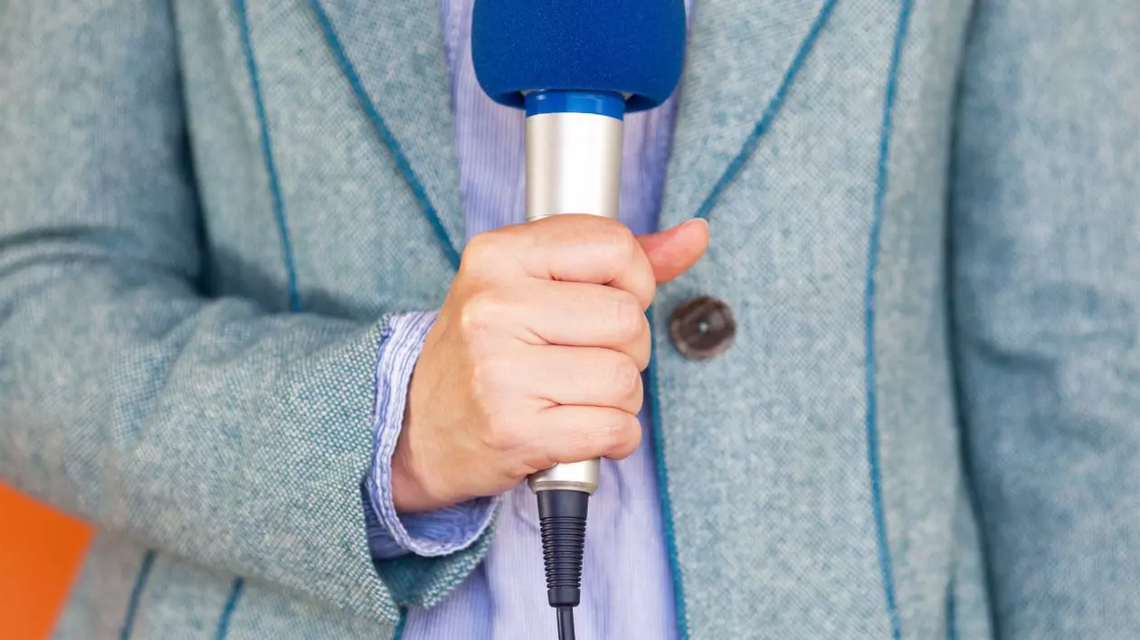 un reporter ține un microfon