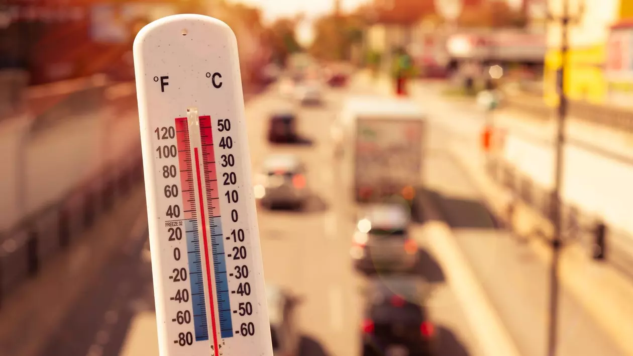 Imagine cu un termometru care indică temperaturi foarte ridicate, iar pe fundal se văd mașini