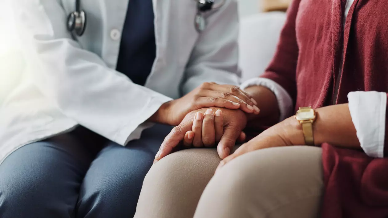 În imagine este ilustrat un doctor care ține mâna unei paciente