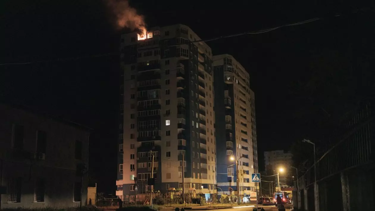 Imagine de noapte cu un bloc, flacari se vad la ultimul etaj, Echipele de urgență sosesc în zona afectată de un atac nocturn în Harkov, Ucraina, pe 5 iunie 2025. Șase lovituri cu rachete au lovit zona, două dintre ele fiind lovituri directe asupra unor clădiri rezidențiale de apartamente