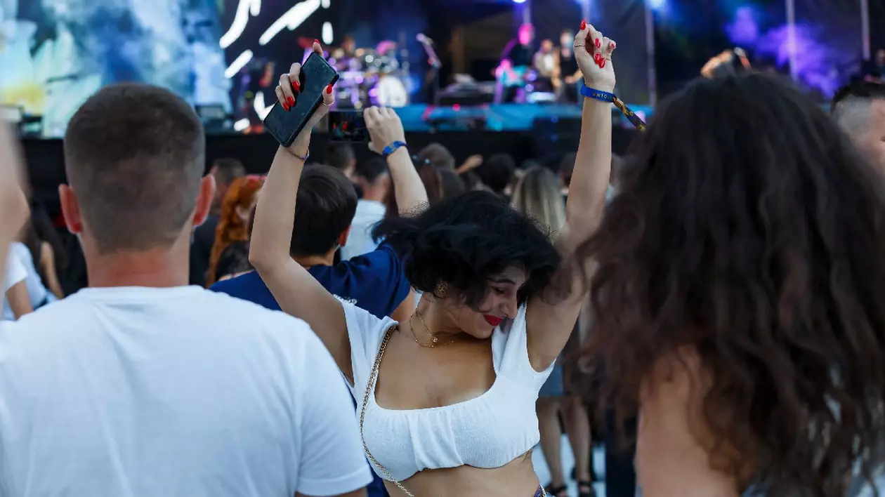 Tineri îmbrăcați în alb, dansează la festivalul de muzica Untold desfasurat in Cluj-Napoca, vineri 9 august 2024.