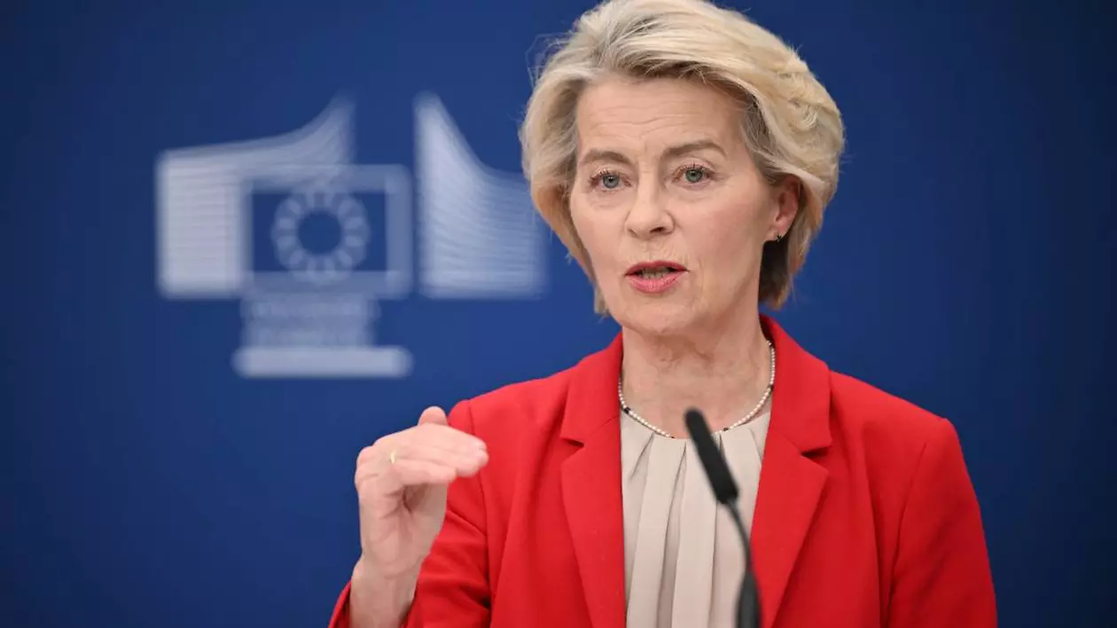 Președinta Comisiei Europene Ursula von der Leyen în timpul unei conferințe de presă, gesticulează cu mâna dreaptă și poartă un sacou roșu.