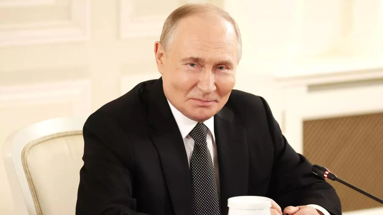 Președintele rus Vladimir Putin stând la masa, poartă un costum negru și vorbește la microfon.