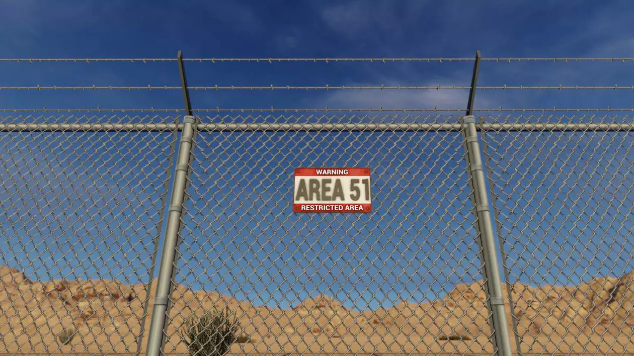 Un afiș cu Area 51 așezat pe un gard din sârmă în deșertul Nevada din SUA.