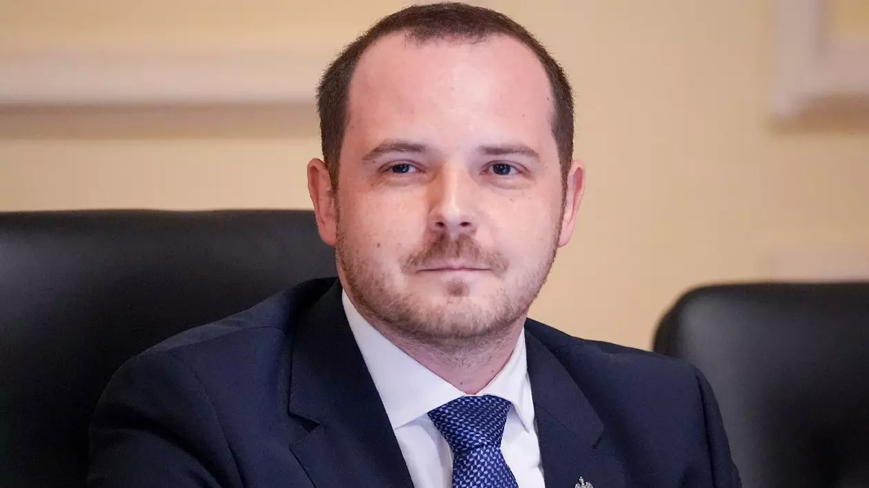 Alexandru Rogobete, într-un costum negru și o camasa alba și cravată albastra