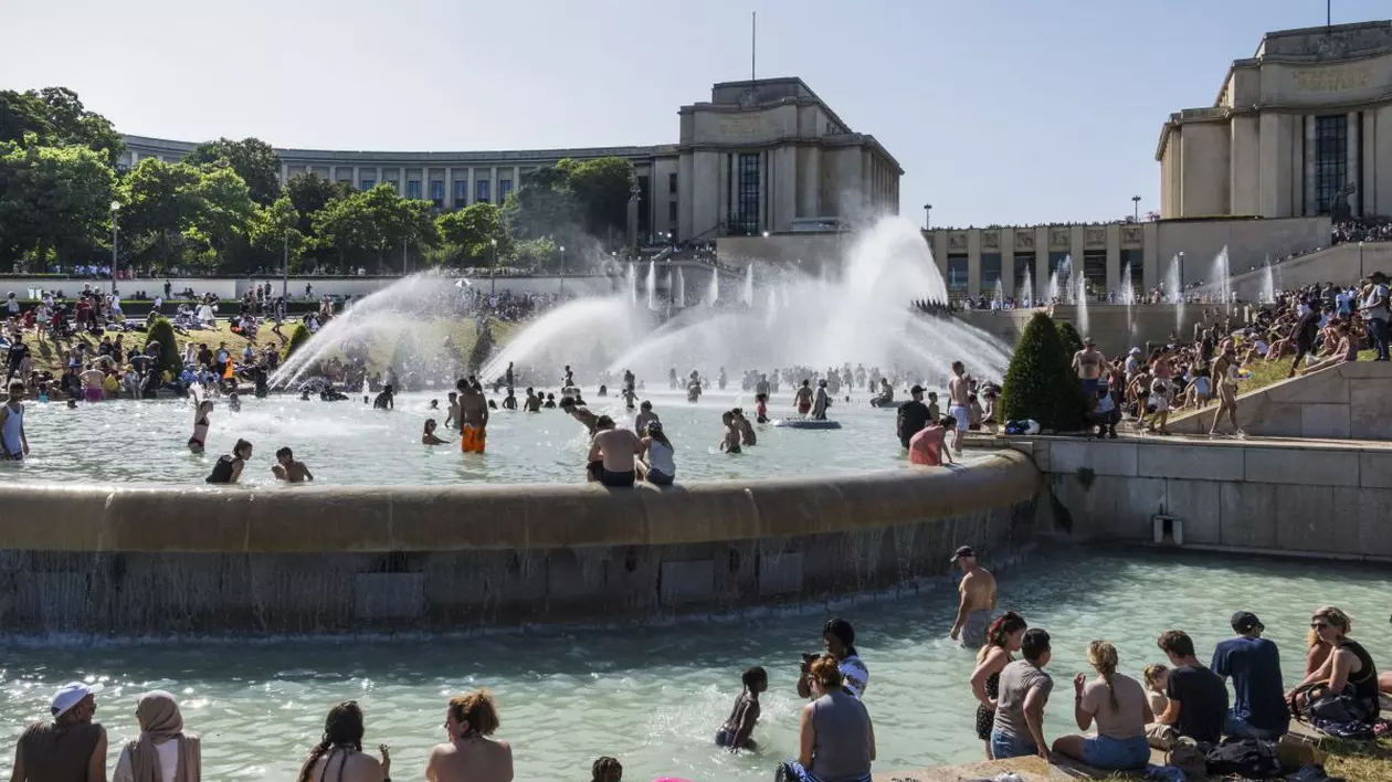 Numeroși turiști se scaldă în fântâna arteziană sau stau la soare în grădina Trocadero din Paris, iunie 2019