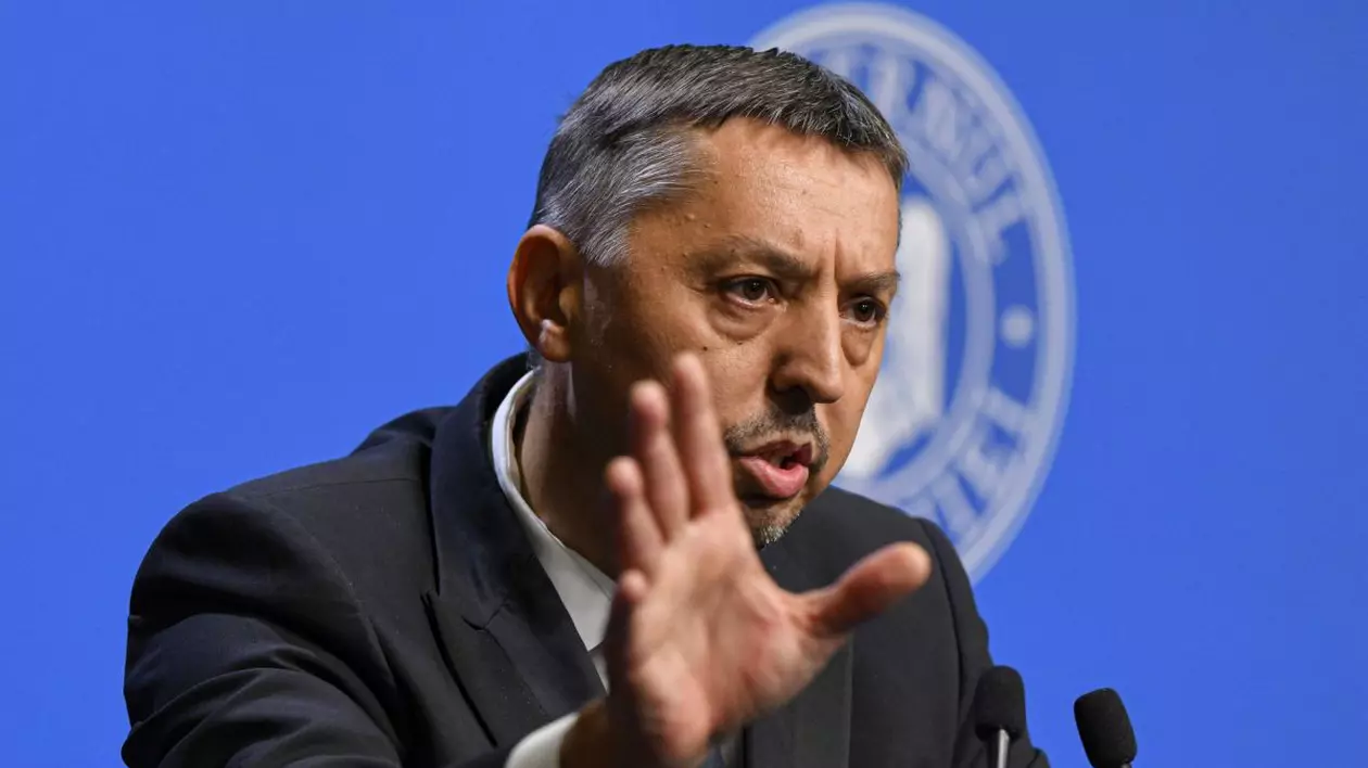 Daniel David gesticulează cu mâna dreaptă în timpul unei conferințe de presă susținută în sediul guvernului, iulie 2025