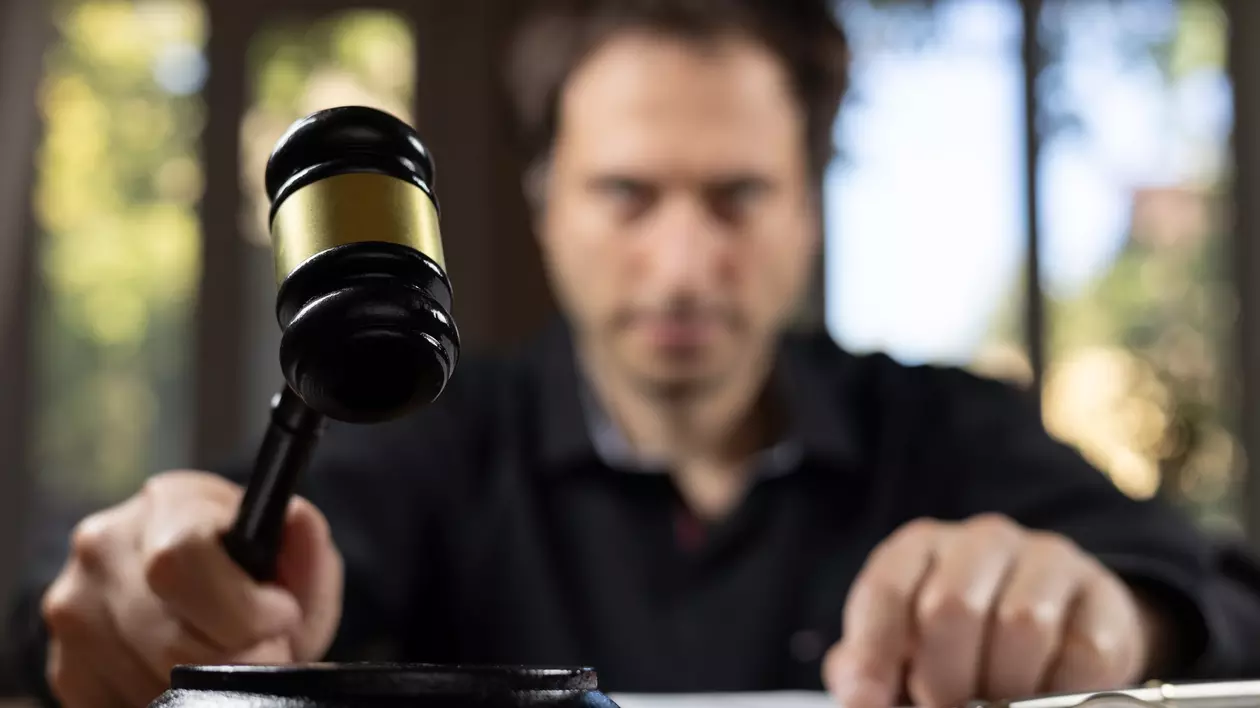 Un judecator da verdictul si arata cu mana spre mai multe documente