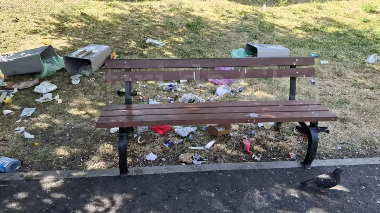 Tomberoane de gunoi rupte și aruncate, gunoi pe iarbă, într-un parc din Cluj, iulie 2025