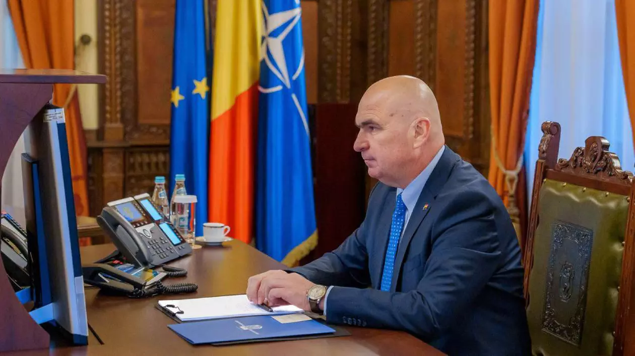 Premierul Ilie Bolojan în momentul în care era președinte interimar, fotografiat stând la biroul său de la Palatul Cotroceni