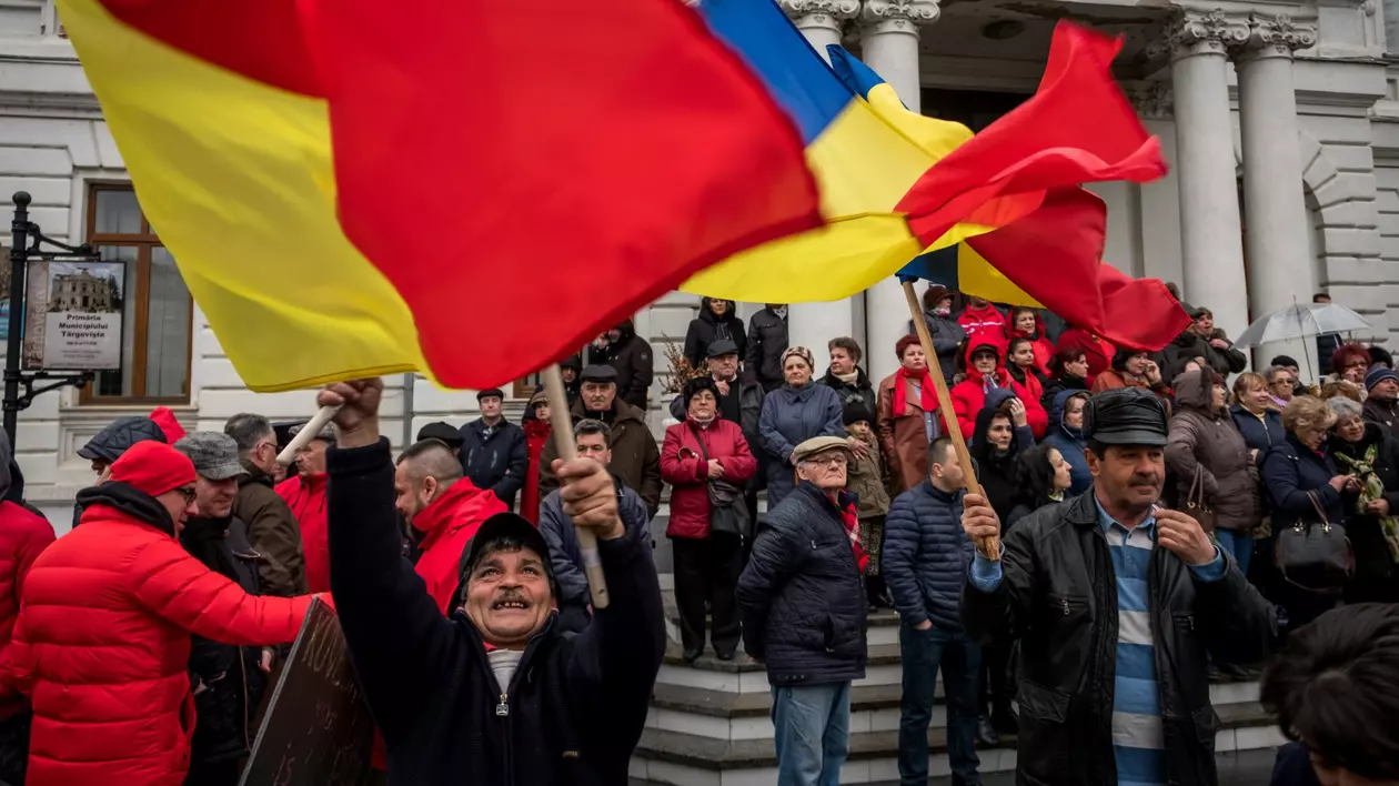 Protestatari care flutură steagul României