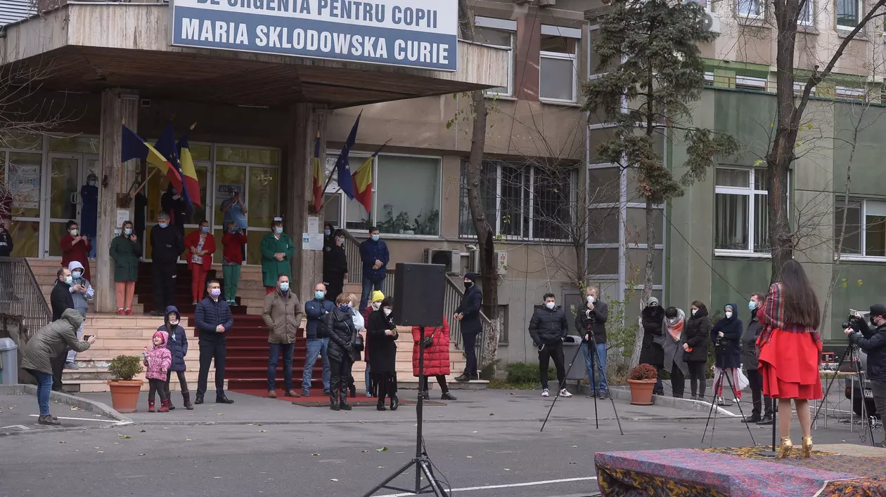 Mai multe persoane cu măști la gură stau pe treptele Spitlaului de Copii Marie Curie din București, decembrie 2020