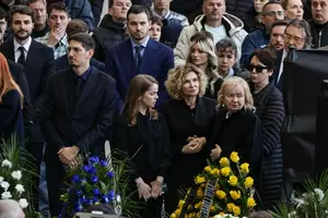 Neli Lucescu, ținută în brațe de fiul Răzvan, la priveghiul marelui Lucescu, pe Arena Națională. În lacrimi, în fața sicriului acoperit de tricolor, o...