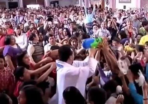 La asta nu te-ai fi gândit! Un preot foloseşte un pistol de jucărie pentru a răspândi apa sfinţită! | VIDEO