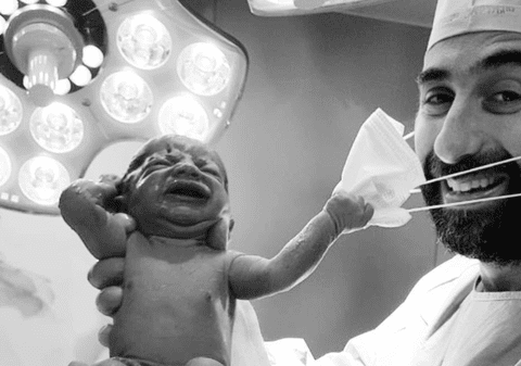 Imagine virală: Un nou-născut smulge masca medicului imediat după ce vine pe lume. „Cu toții vrem un semnal că ne vom da jos în curând măștile”