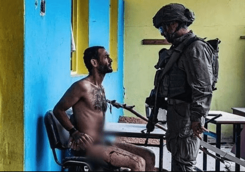 Soldat israelian care interoghează un palestinian dezbrăcat, legat la mâini și plin de sânge. Experți juridici: „Rele tratamente aplicate prizonierilor”