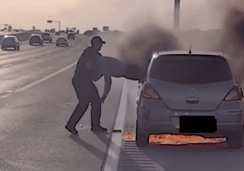 Momentul în care un polițist ajută un șofer să iasă pe geam, după ce mașina în care se afla a luat foc, pe o autostradă din Texas