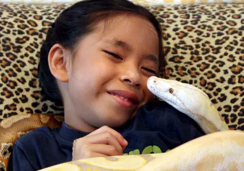 La şapte ani, trăieşte înconjurată de zeci de pitoni şi reptile