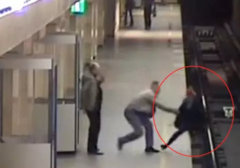 MOMENTUL GROAZEI! Filmat în timp ce împingea o femeie pe şinele de metrou