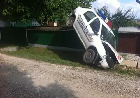 Mașină a poliţiei atîrnată de un gard după o acţiune de urmărire | FOTO