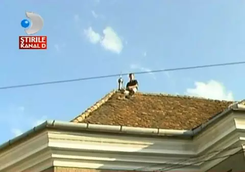 SPIDERMAN ar fi invidios! Protestatarul din Cluj care s-a urcat pe acoperișul BISERICII și a folosit CRUCEA drept cuier! VIDEO