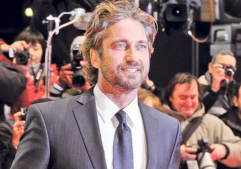 Gerard Butler hrăneşte orfanii români
