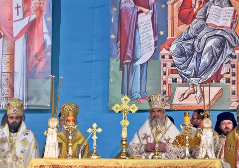 Preoţii, sub umbrare, credincioşii, copţi la soare